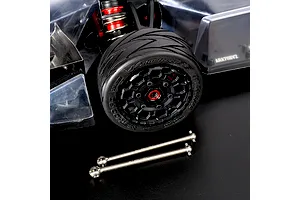 Two titanium CVD axle shafts laid in front of an RC car wheel and body assembly on a dark surface.