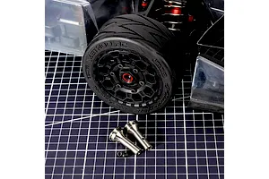 Method RC titanium CVD stub axles with associated hardware displayed in front of an RC car wheel on a cutting mat.