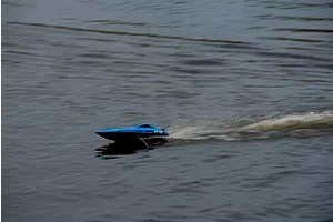 Atrek Riptide blue RC speed boat running across open water, creating a white spray wake.