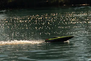 Atrek Rogue RC speed boat speeding across dark water, creating a white wake and spray.