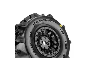 Close-up studio shot of a Pro-Line Dumont paddle tyre mounted on a black split-six rim against a white background.
