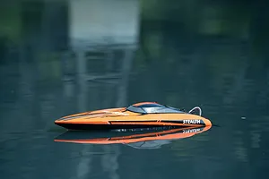 Atrek Stealth orange and black RC speed boat floating on calm water outdoors