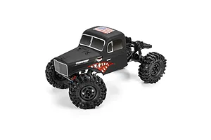 Pro-Line matte black cab-only crawler body mounted on an RC chassis with aggressive off-road tires and shark teeth graphics.