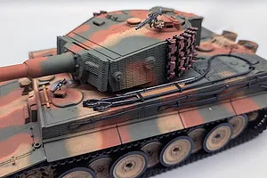 High-angle studio shot of the Taigen German Tiger I RC tank featuring a camouflage paint scheme, turret, and detailed tracks.