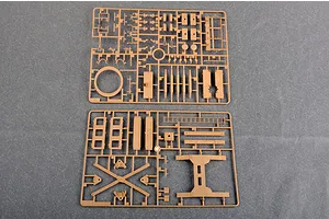 Two tan plastic model kit sprues containing various structural parts for a 1/35 scale military vehicle model, laid out on a grey surface.