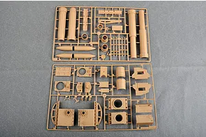 Two tan plastic model kit sprues containing various parts for a German Morser Karl self-propelled gun model, laid out on a grey surface.
