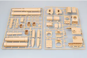 Two tan plastic model kit sprues containing parts for a large artillery piece, including barrel sections and structural components.
