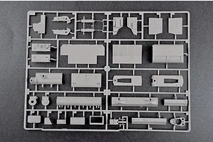 A grey plastic sprue containing various unpainted model kit parts for a military vehicle, set against a dark grey background.