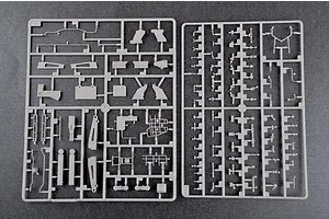 Two grey plastic model kit sprues containing various small parts for a 1/35 scale military vehicle model, laid out on a dark grey surface.