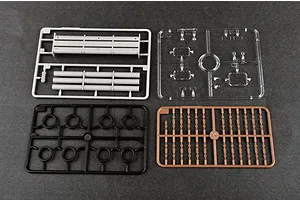 Four plastic model kit sprues on a dark grey background, including grey, clear, black, and brown parts.