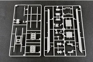 Two grey plastic model kit sprues containing various vehicle parts laid out on a dark grey surface.