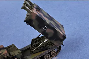 A 1/35 scale plastic model of a MARS rocket launcher vehicle with its launcher pod elevated, featuring a camouflage paint scheme and German military cross.