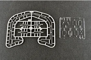 Two plastic model kit sprues on a dark grey background, one grey and one clear, containing small vehicle parts.