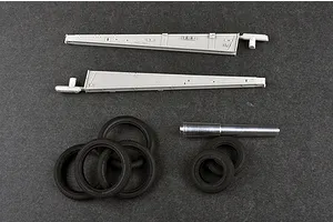 Plastic model kit parts including two long grey trail arms, five black rubber tires, and a metal gun barrel for a 1/35 scale artillery model.