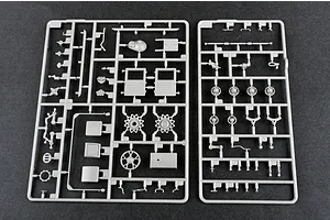 Two grey plastic model kit sprues containing various vehicle parts laid out on a dark surface.