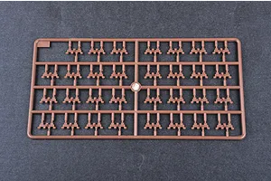 A brown plastic model kit sprue containing multiple small tank track link parts on a dark grey background.