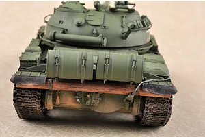 Rear view of a 1/35 scale model of a Russian T-62 tank, showing the olive green hull, rear fuel drums, and wooden log detail.
