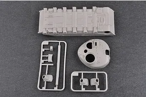 Unassembled grey plastic model kit parts for a tank, including the lower hull, turret, and sprue frames on a dark grey background.