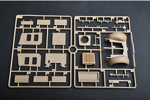 A tan plastic model kit sprue containing various vehicle body panels and parts for a 1/35 scale military model.
