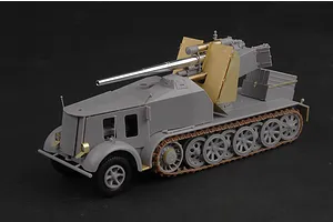A 1/35 scale plastic model kit of a German 8.8cm Flak 18 half-track self-propelled gun, partially assembled in grey plastic with brass photo-etched parts.