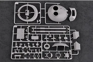 Two grey plastic model kit sprues containing tank turret and gun barrel parts on a dark textured background.
