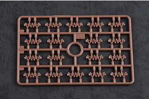 A brown plastic model kit sprue containing multiple small tank track link components on a dark textured background.