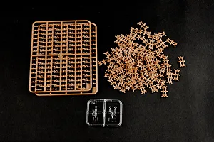 Plastic model kit parts including tan sprue frames and a small clear sprue on a black background.