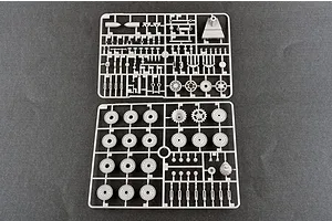 Two grey plastic model kit sprues containing various tank wheels, suspension parts, and small components on a dark background.