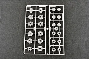 A grey plastic sprue containing various tank road wheels for a 1/35 scale model kit, viewed from above against a dark grey background.