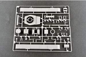 A grey plastic model kit sprue containing various tank parts, including turret components and side panels, on a dark grey background.