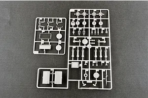 Three grey plastic model kit sprues containing various tank parts laid out on a dark grey surface.