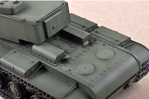A high-angle view of a 1/35 scale plastic model of a Russian KV-220 tank, showing the olive green turret and engine deck detail.