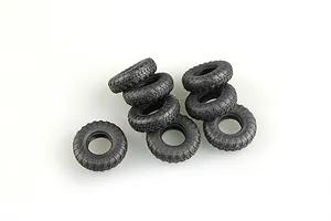 A cluster of eight black rubber model vehicle tires with detailed tread patterns on a white background.
