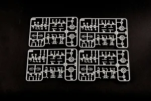 Four identical grey plastic model kit sprues arranged in a grid on a black background.
