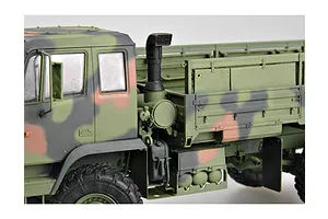 Close-up side view of a 1/35 scale model M1078 military cargo truck with camouflage paint, showing the cab, exhaust stack, and cargo bed.