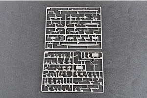 Two grey plastic model kit sprues containing various vehicle parts laid out on a dark grey surface.
