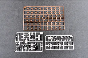 Three plastic model kit sprues from a Trumpeter tank kit, including one brown sprue and two grey sprues on a grey background.