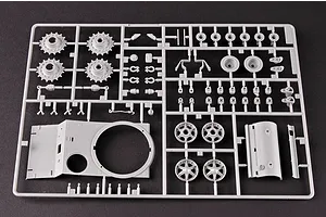 A grey plastic sprue containing various tank model parts, including wheels, turret components, and small mechanical details for a 1/35 scale model kit.