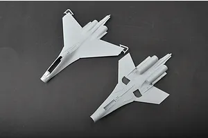 Top and bottom views of unpainted grey plastic model aircraft fuselage parts for a Trumpeter Su-30MKK kit on a dark grey background.