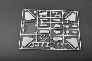 A grey plastic model kit sprue containing various aircraft parts like wings, landing gear, and cockpit components on a dark surface.