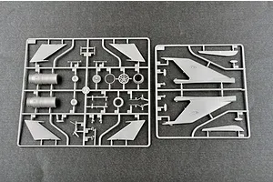 Two grey plastic model kit sprues containing aircraft parts like wings, engine components, and landing gear on a dark grey background.