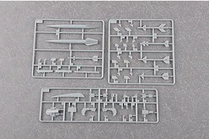 Three grey plastic model kit sprues containing various aircraft parts, including missiles and structural components, on a textured grey background.