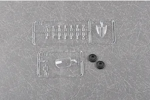 Clear plastic model kit sprues labeled Y3 and Y4, including a canopy part and two small black rubber tires on a grey textured background.