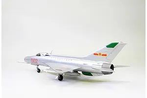 A side-profile view of a fully assembled and painted 1/48 scale MiG-21F-13 model aircraft in a silver finish with red and green markings.