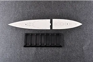 Two light grey plastic battleship deck sections and a black plastic display stand on a dark grey textured surface.