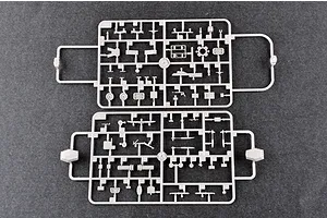 Two grey plastic model kit sprues containing various small battleship parts laid flat on a dark grey surface.