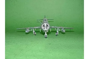 Front view of a finished 1/48 scale MiG-15 UTI Midget model aircraft on a green background.