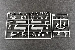 Two grey plastic model kit sprues containing various aircraft parts like landing gear, wheels, and cylindrical components on a dark grey background.