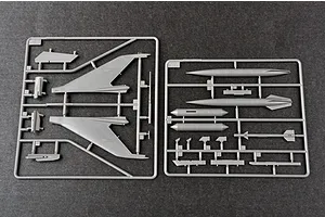 Two grey plastic model kit sprues containing aircraft wings, fuel tanks, and missile parts on a dark grey background.
