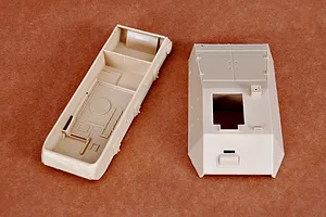 Unassembled plastic model kit parts for a 1/35 scale German artillery vehicle, showing the main hull and upper deck pieces in tan plastic.